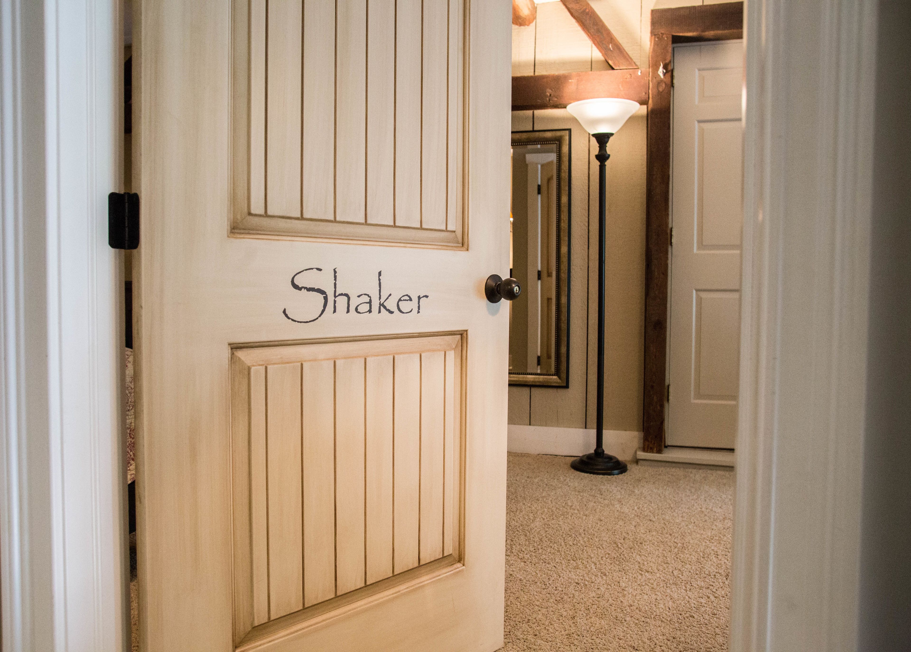 A hallway with a door labeled "Shaker" leading to a room.