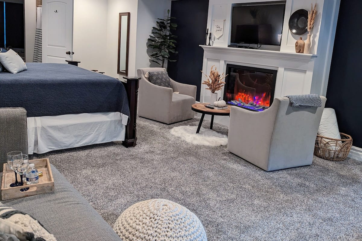 Ein modernes Wohnzimmer mit Kamin, einem großen Bett und einem Fernseher.