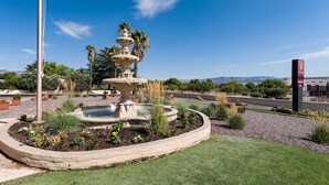 A landscaped fountain with a tiered design, surrounded by a circular garden bed with various plants and flowers. - Lux Verde Hotel (Cottonwood)
