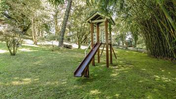 Un parque infantil con un tobogán y una estructura de madera.