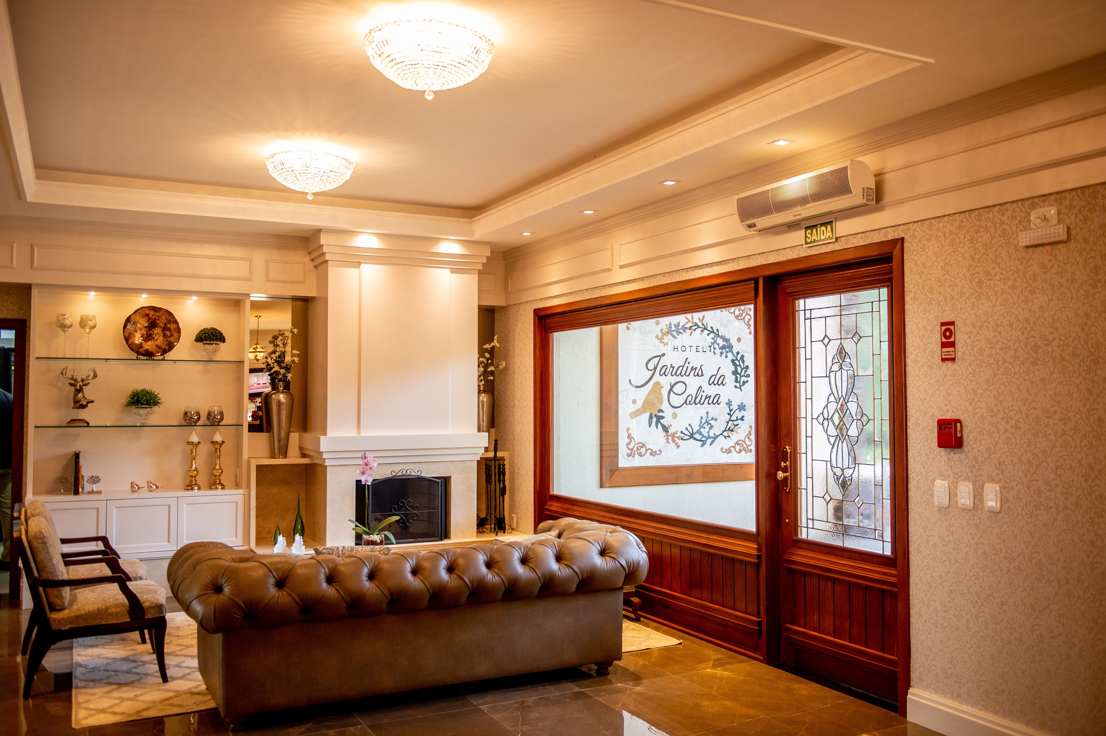 A hotel lobby with a fireplace, a plush sofa, and a decorative wall with a sign.
