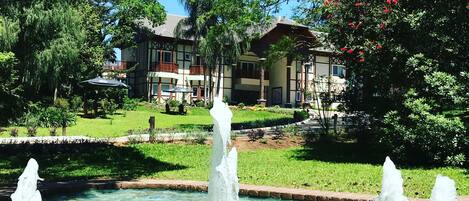 Un patio con una fuente, una piscina y un edificio con balcones.