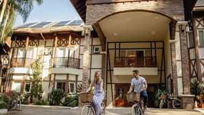 A building with a stone facade, wooden balconies, and solar panels on the roof. - Hotel Jardins da Colina (Nova Petropolis)
