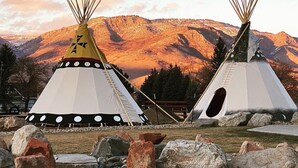 Two tipi-style tents with a mountainous backdrop. - Compass Rose Lodge (Huntsville)