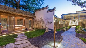 A traditional Japanese-style building with a thatched-roof structure and a modern glass extension. - Old Street Moye Inn (Huangshan)