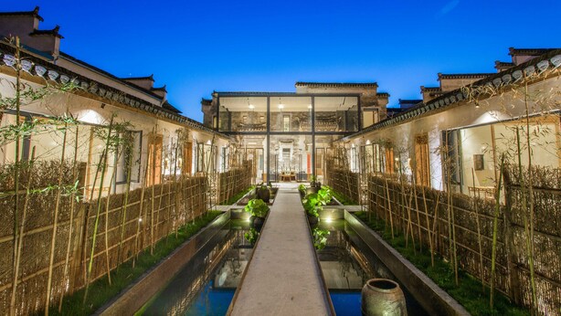 A traditional courtyard with a central water feature, surrounded by buildings with classic architecture. - Old Street Moye Inn (Huangshan)