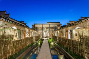 A traditional courtyard with a central water feature, surrounded by buildings with classic architecture. - Old Street Moye Inn (Huangshan)