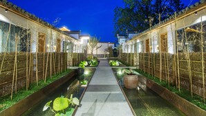 A traditional courtyard with a central pathway, bamboo fences, and water features. - Old Street Moye Inn (Huangshan)