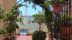 A courtyard with tiled flooring, a metal gate, and a tree. - Penthouse Duplex, Fuengirola (Los Pacos) (Fuengirola)