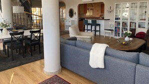 A spacious living room with a grey sofa, a wooden coffee table, and a dining area with a white table and black chairs. - Penthouse Duplex, Fuengirola (Los Pacos) (Fuengirola)