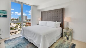 Une chambre d’hôtel moderne avec un grand lit, une vue sur la ville et un balcon.