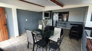 A modern kitchen with a glass dining table, black chairs, and a built-in oven.