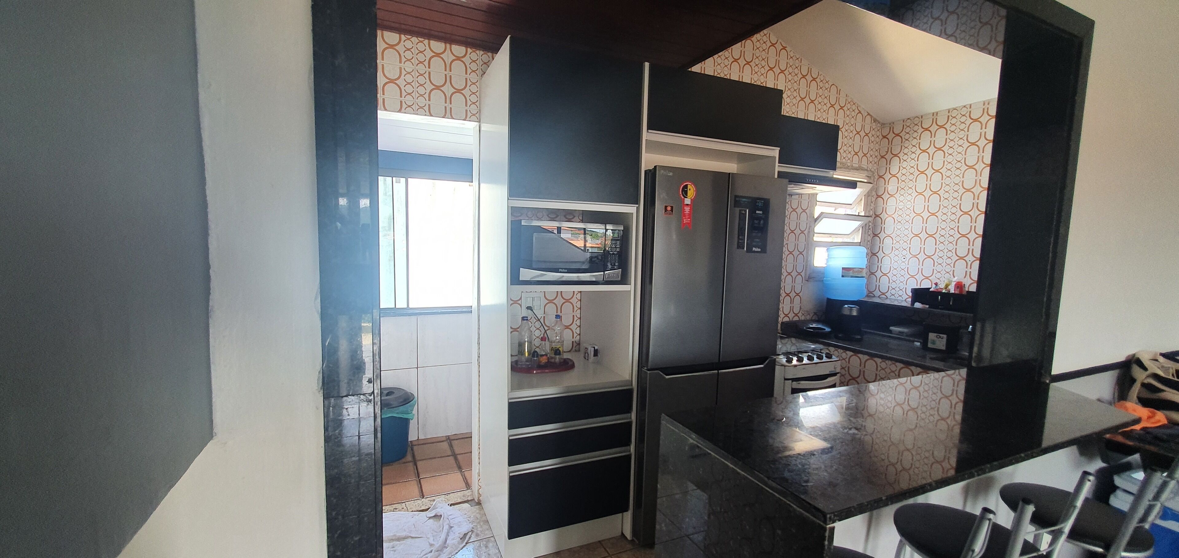 Cocina pequeña con refrigerador, microondas y estufa.