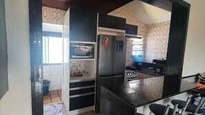 A compact kitchen with a refrigerator, microwave, and stove.