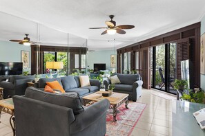 A spacious living room with a sofa set, a coffee table, and a television.