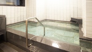 A swimming pool with a metal handrail, tiled walls, and a stone floor. - Hotel Kuretakesou Hiroshima Otemachi (Hiroshima)