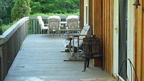 A wooden deck with outdoor furniture and a door to a building.