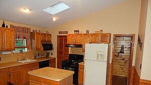 A kitchen with wooden cabinets, a microwave, a stove, and a refrigerator.