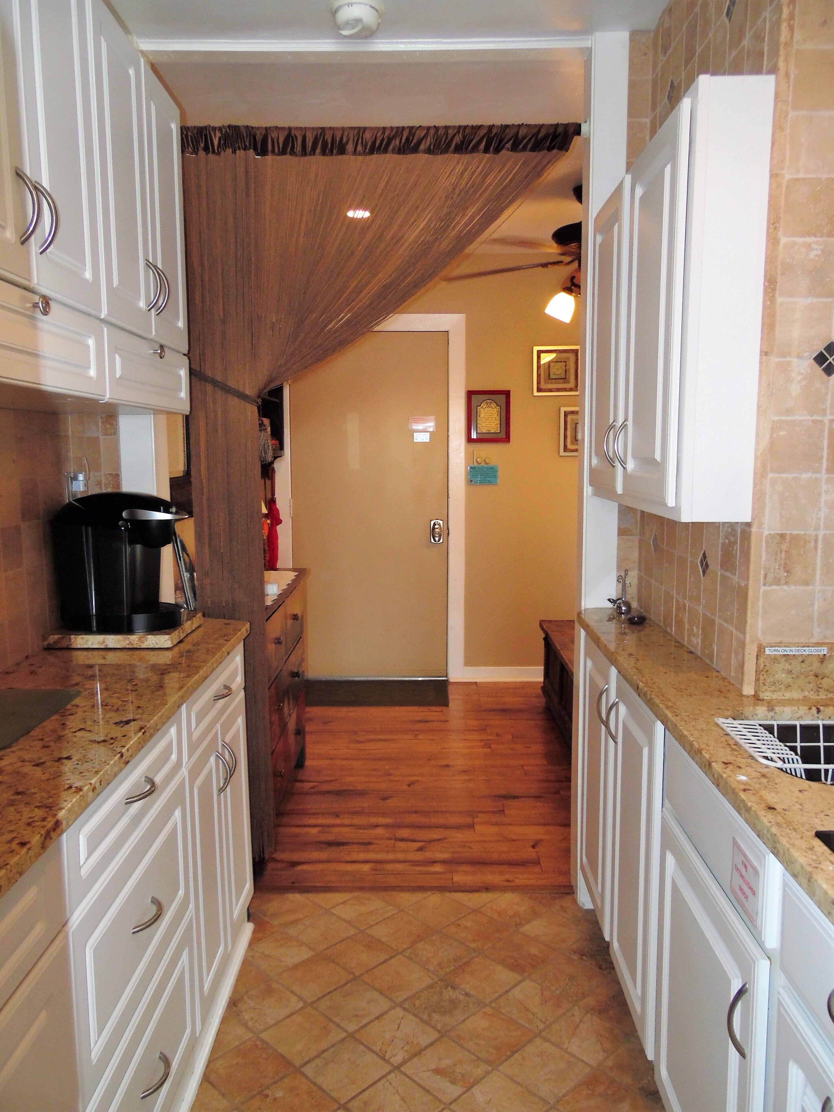 A kitchen with wooden cabinets, a granite countertop, and a tiled backsplash.
