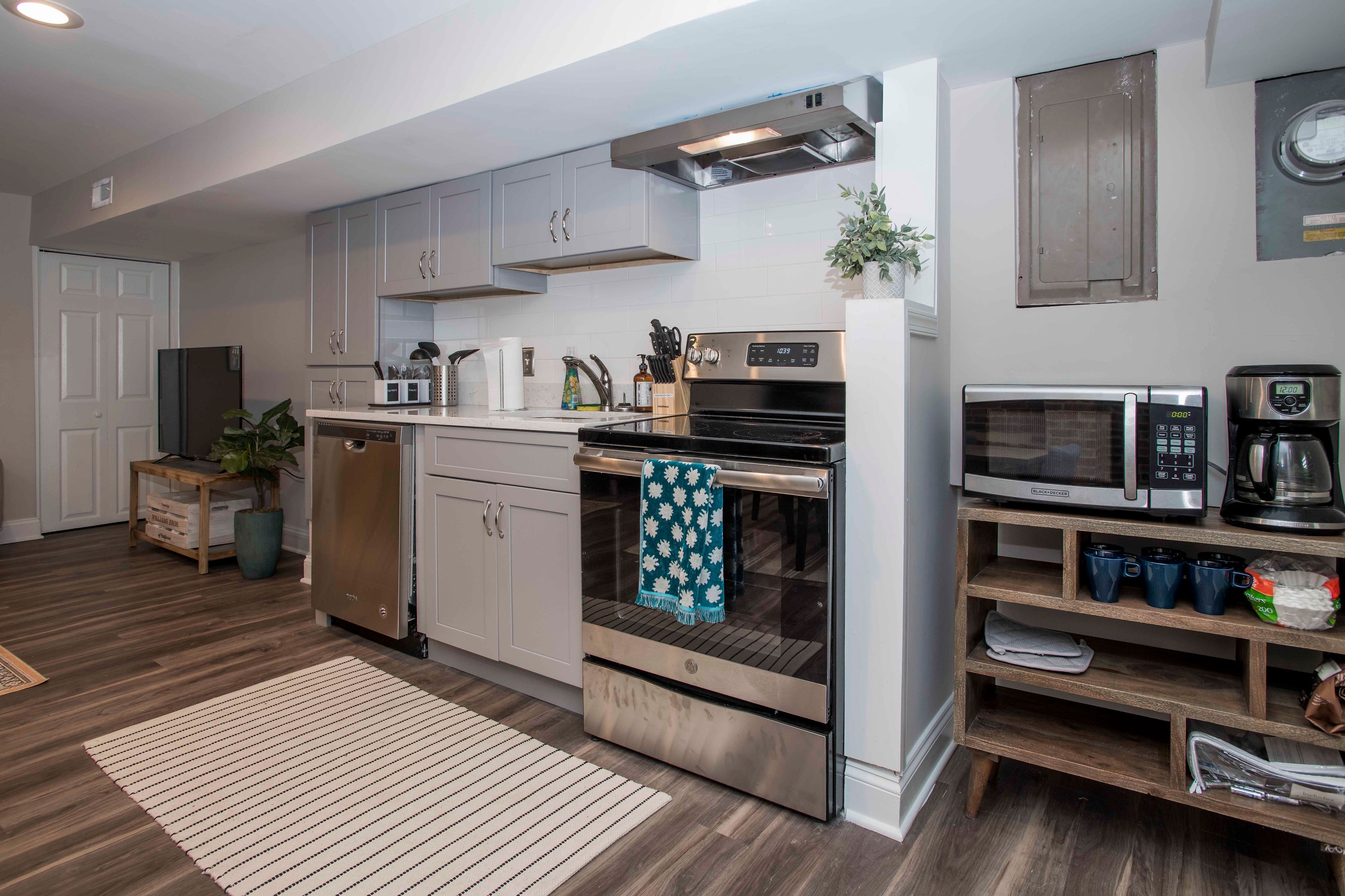 A modern kitchen with stainless steel appliances, wooden cabinets, and a built-in oven.