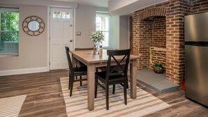 Une cuisine équipée d’un four à briques, d’un réfrigérateur et d’une table à manger avec des chaises.