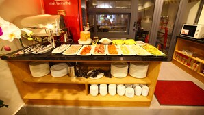 A buffet counter with various food items and a Coca-Cola refrigerator. - Saigonciti Hotel (Ho Chi Minh City)