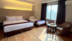 A hotel room with two beds, a small table, and a chair. - Atrium Boutique Hotel (Bangkok)