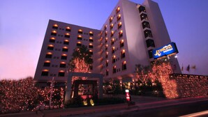 A multi-story hotel with a prominent entrance, illuminated windows, and a visible sign for a boutique hotel. - Atrium Boutique Hotel (Bangkok)