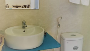 A bathroom with a white sink, a mirror, a toilet, and a towel rack. - Tram Huong (Da Nang)