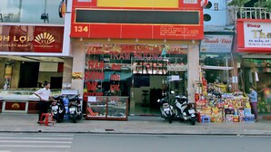 A hotel with a yellow and red facade, multiple windows, and a sign for 'Tram Huong Hotel'. - Tram Huong (Da Nang)