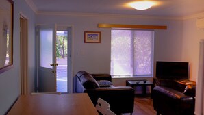 Ett vardagsrum med en soffa, en tv och ett matbord.