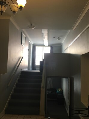 Stairs lead to a cozy upper floor with a landing area featuring a table and chair.