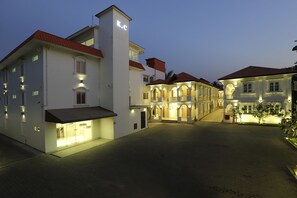 A hotel with a central courtyard, multiple balconies, and a well-lit facade.