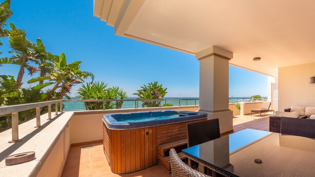 A balcony with a hot tub, outdoor seating, and a view of the ocean. - 102 Luxury Serv Apart-Estepona 3 Bed, 28c Heated 20m Pool, Jacuzzi - an Oasis (Estepona)