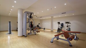 A spacious gym with various exercise machines, a pull-up bar, and a wall-mounted screen. - 102 Luxury Serv Apart-Estepona 3 Bed, 28c Heated 20m Pool, Jacuzzi - an Oasis (Estepona)