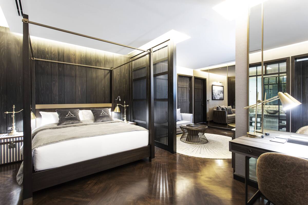 Une chambre moderne avec un grand lit, un bureau et une chaise.