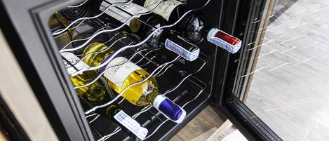 Prateleira para vinhos com garrafas dentro de um armário com moldura preta.