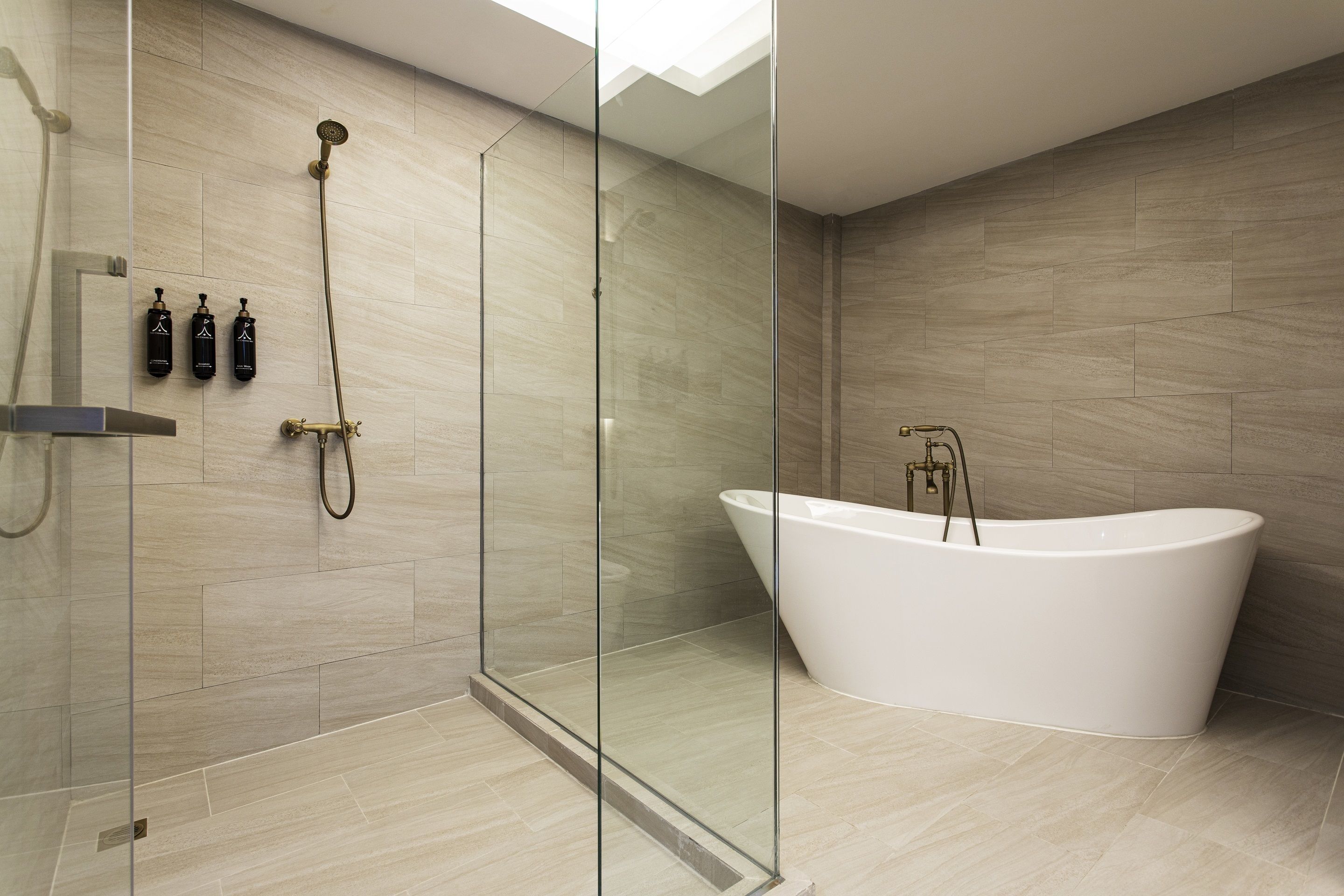 A modern bathroom with a freestanding bathtub, a glass-enclosed shower, and a wall-mounted faucet.