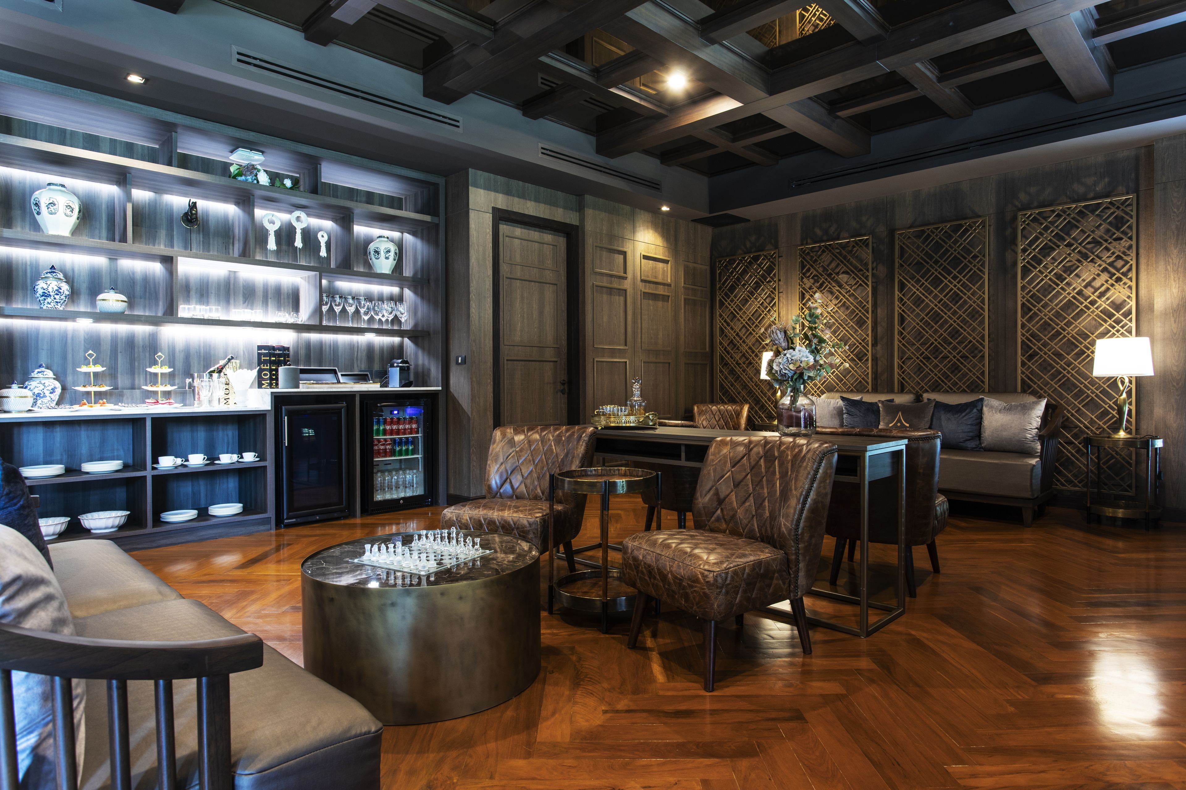 Un interior moderno con una zona de bar, asientos y una pared decorativa.