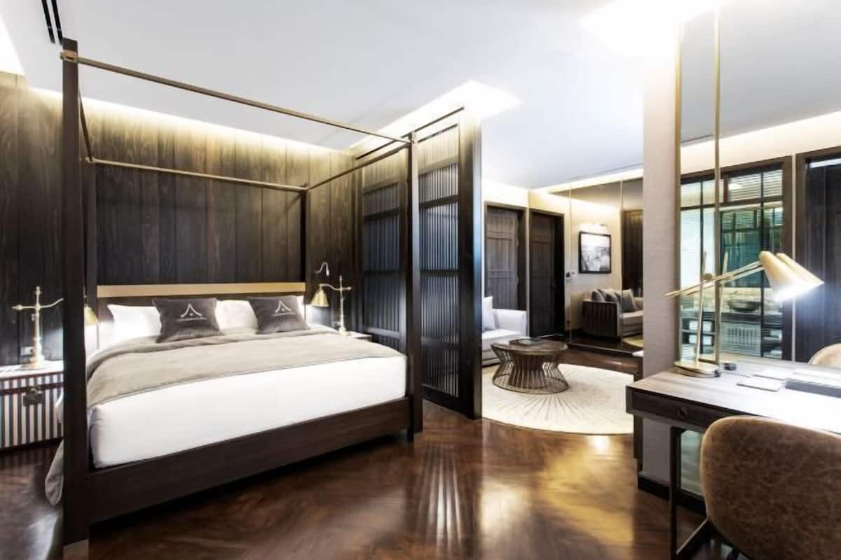 Une chambre à coucher moderne avec un lit à baldaquin, un bureau et une chaise.