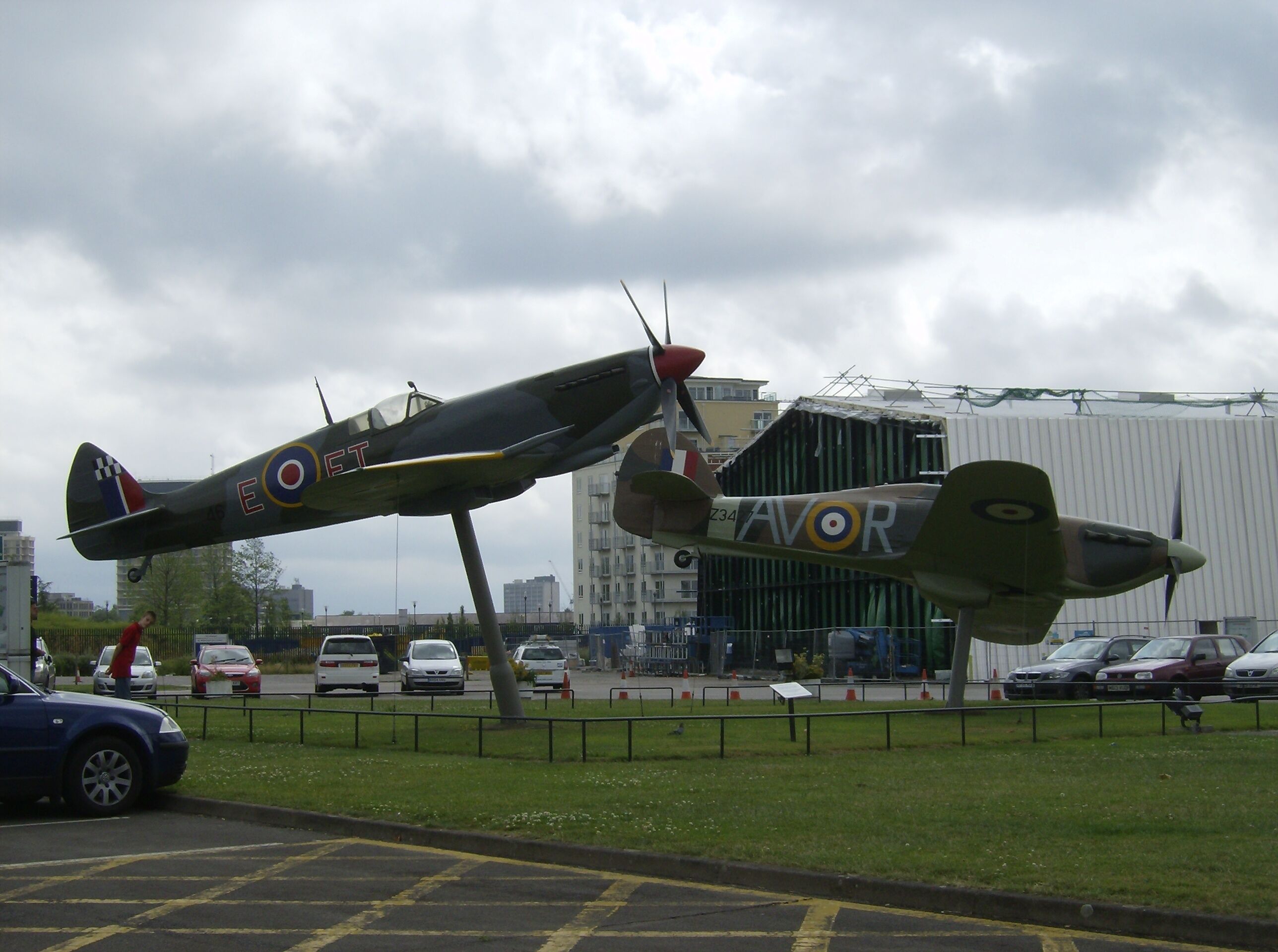 Two WWII aircraft on display in an outdoor museum setting.