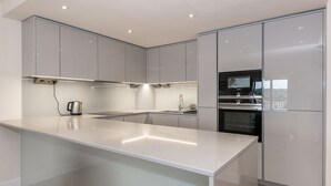 A modern kitchen with a large island, stainless steel appliances, and a view of the city. - A luxury, contemporary 2Bed & 2Bath Apartment Next to London Museum (London)