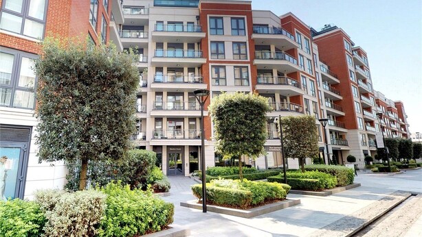 A multi-story residential building with balconies, a landscaped courtyard, and a clear sky. - A luxury, contemporary 2Bed & 2Bath Apartment Next to London Museum (London)
