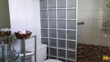 A bathroom with a white toilet, a glass sink, and a tiled floor.