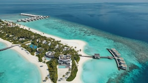 An aerial view of a resort with overwater bungalows, a beach, and clear turquoise waters. - Jumeirah Olhahali Island  (Olhahali)