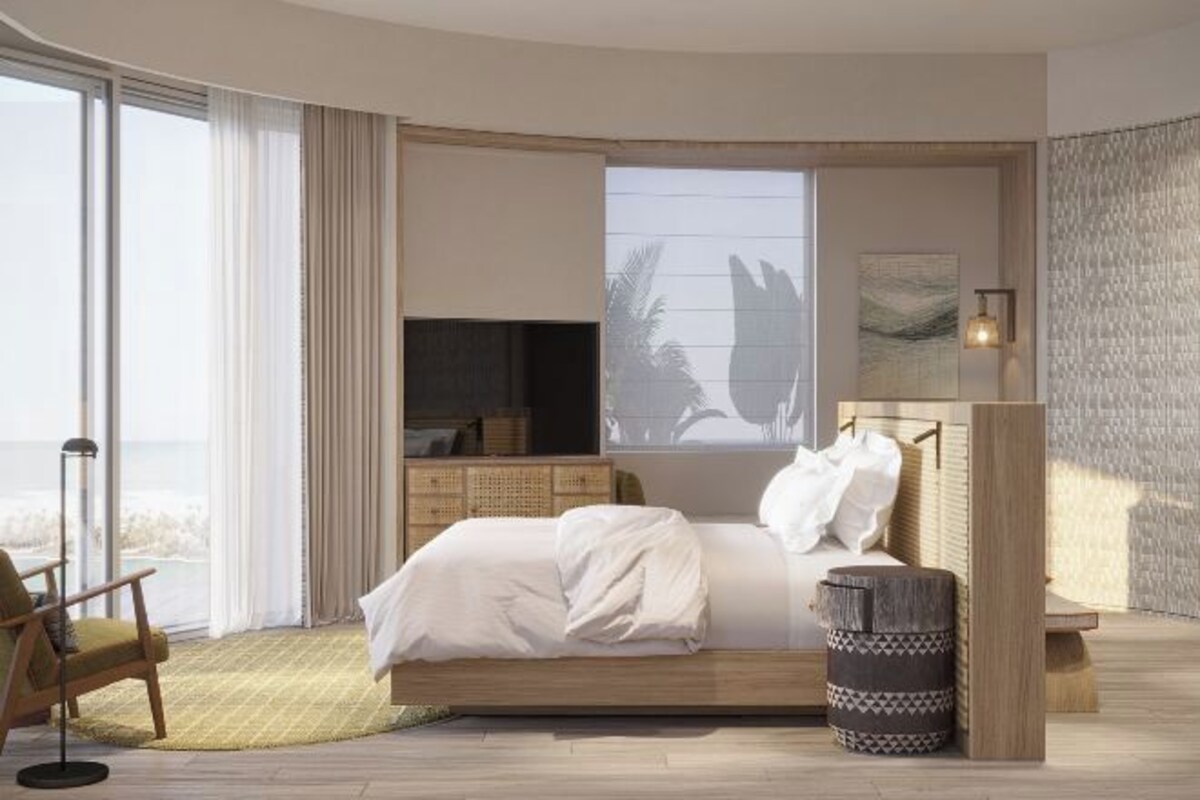 A bedroom with a bed, a chair, a window, a wall art piece, and a lamp.