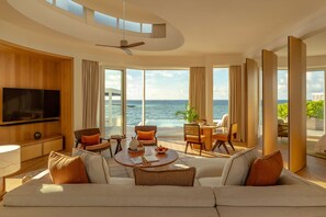 A spacious living room with a large flat-screen TV, comfortable seating, and a view of the ocean. - Jumeirah Olhahali Island  (Olhahali)