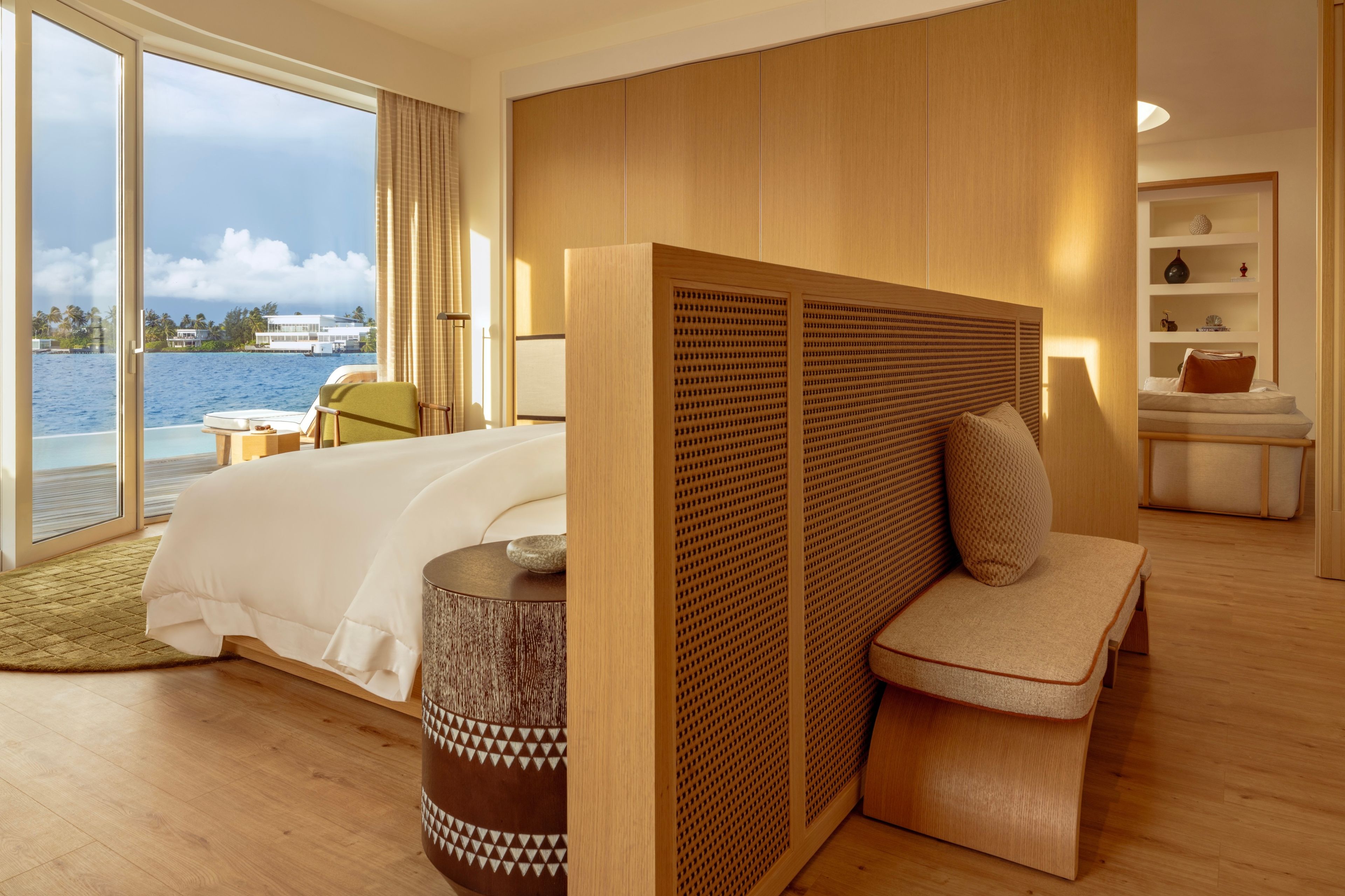 Una habitación de hotel moderna con una cama grande, un área de descanso y vista al mar.