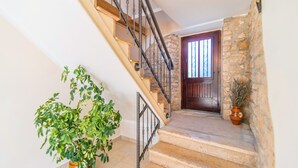 Un escalier avec des murs en pierre et une porte en bois en haut.