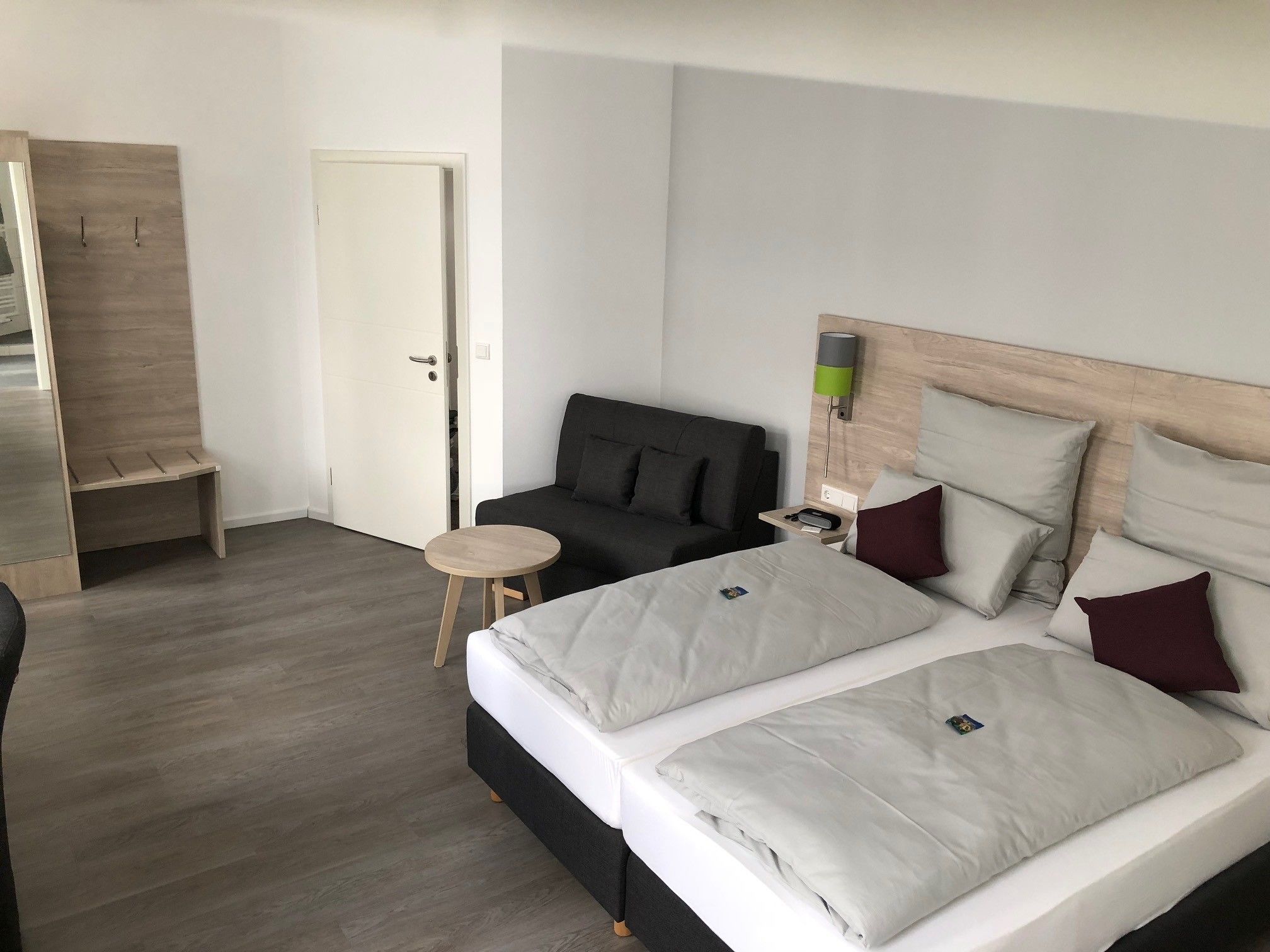Ein Hotelzimmer mit einem Bett, einem kleinen Tisch, einer Couch und einer Tür.